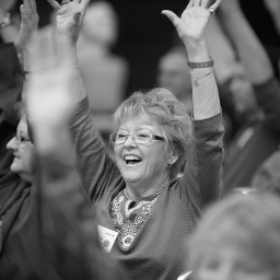 The Victory Summit attendee raises arms and laughs