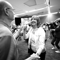 Group of mature adults dance together at convention center