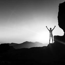 Woman climber success silhouette in mountains, ocean and sunset