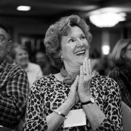 Mature The Victory Summit event attendee smiles and claps