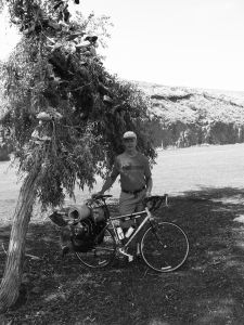Mature Man with bike by tree