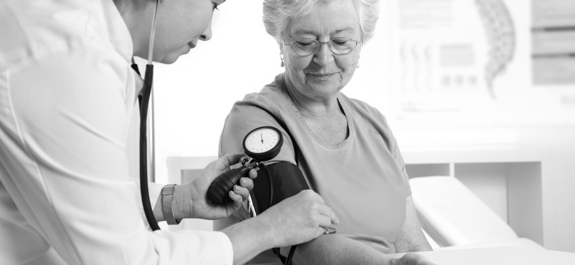 Female doctor measuring blood pressure of senior women