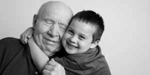 Grandfather with Parkinson's and grandson share a hug