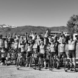 Cycling Team of men and women raise arms in victory