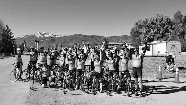 Cycling Team of men and women raise arms in victory