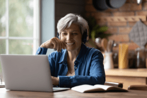Woman sitting and smiling at computer desk