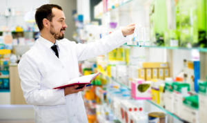 Male pharmacist looking at inventory and taking notes