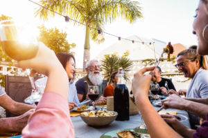 Group of people laughing and dining outdoors