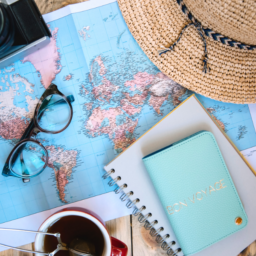 world map with glasses, camera, journal and sunhat