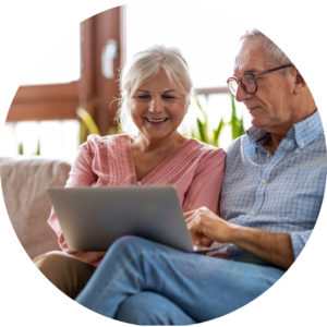 older couple sitting on couch with computer