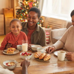African-American family enjoying tea and snacks while celebrating Christmas at home