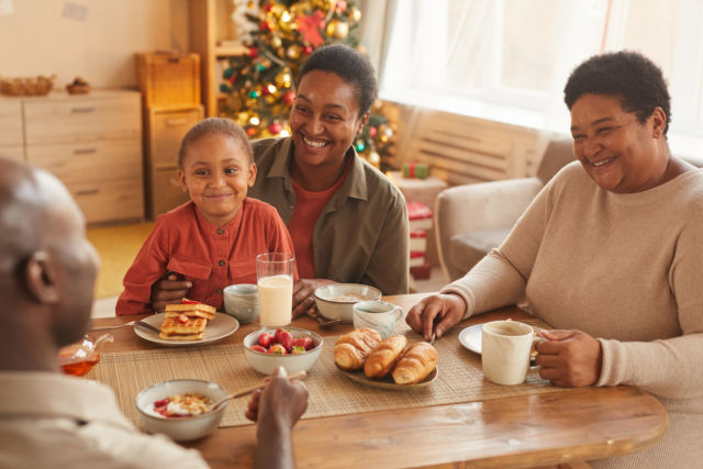 African-American family enjoying tea and snacks while celebrating Christmas at home