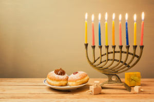 Hanukkah celebration with menorah and sufganiyot on wooden table