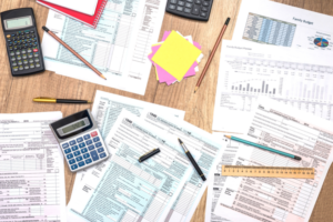 Calculators, pencils, ruler, and tax documents on table