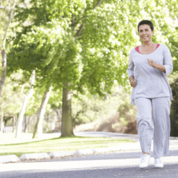Smiling woman jogs in park