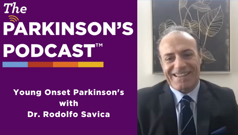 The Parkinson's Podcast logo with the words "Young Onset Parkinson's with Dr. Rodolfo Savica" is on the left side of the picture. The right side of the picture is a picture of Rodolfo Savica. He is in front of a black abstract painting and white wall. He is a balding, white man, wearing a charcoal suit, a blue shirt, and a striped navy tie.