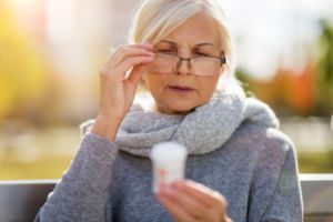 woman checking label on medication