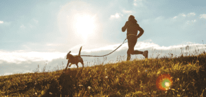 Man jogging outdoors with his dog