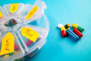 Weekly organizer with pills on blue background
